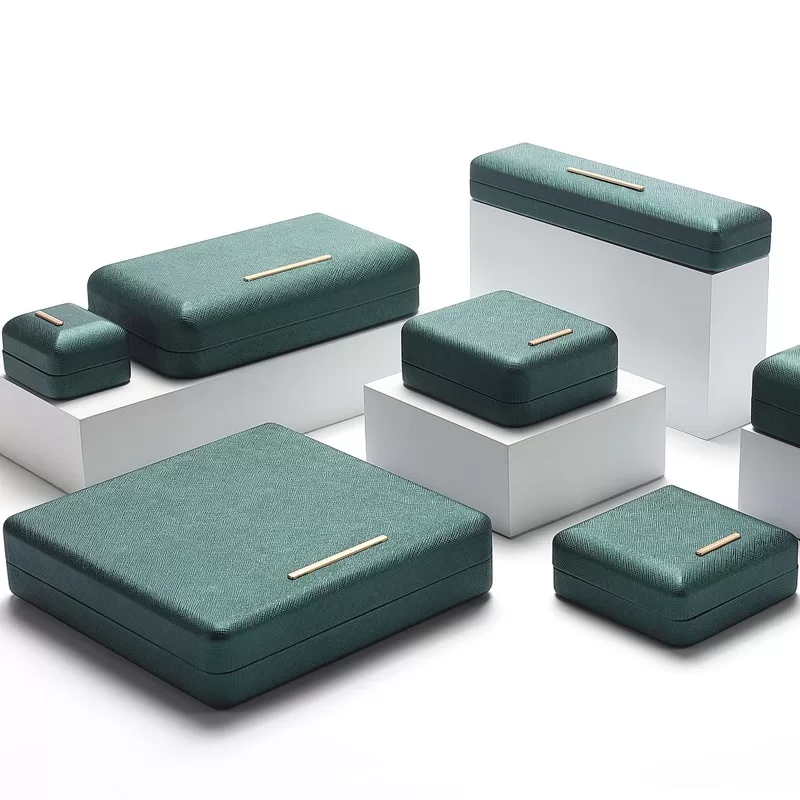 Close up of gold bar decoration on arched green PU leather box.