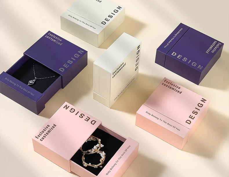 Open slide-out jewelry box revealing black sponge insert for ring storage