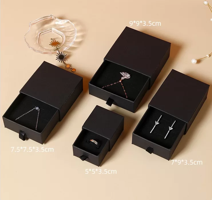Black ribbon pull tab detail on slide-style jewelry packaging