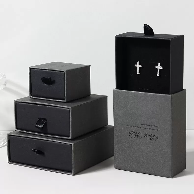 Open black slide-out box revealing black velvet sponge insert for rings