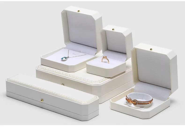 Close up of gold stamped pattern on white leather jewelry box lid.