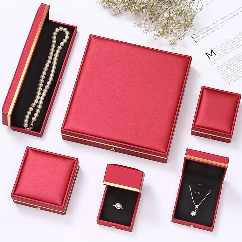 Open square leather ring box with black velvet interior.