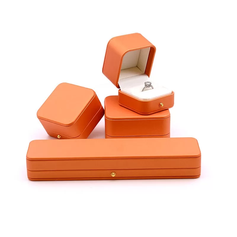 Interior view of cream velvet lining in orange jewelry packaging.