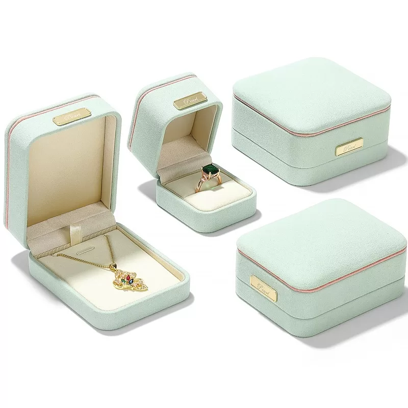 Light green microfiber ring box with orange trim and gold bar decoration