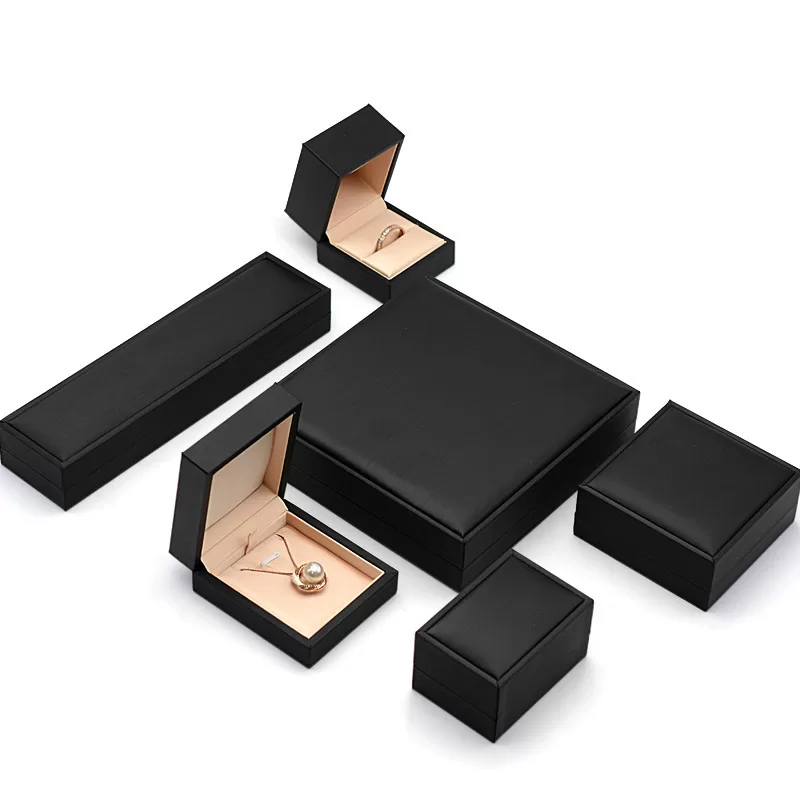 Open black jewelry box showing rose gold satin and velvet lining