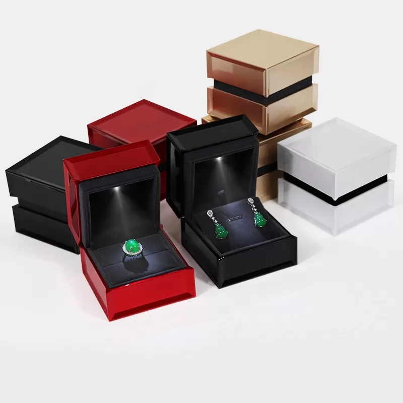 Luxury piano gloss LED ring box in red with spotlight illuminating diamond