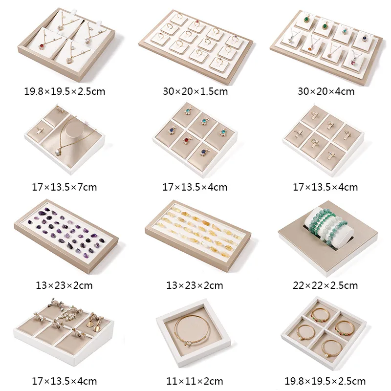 Champagne brushed leather jewelry display tray with white border holding earrings and rings